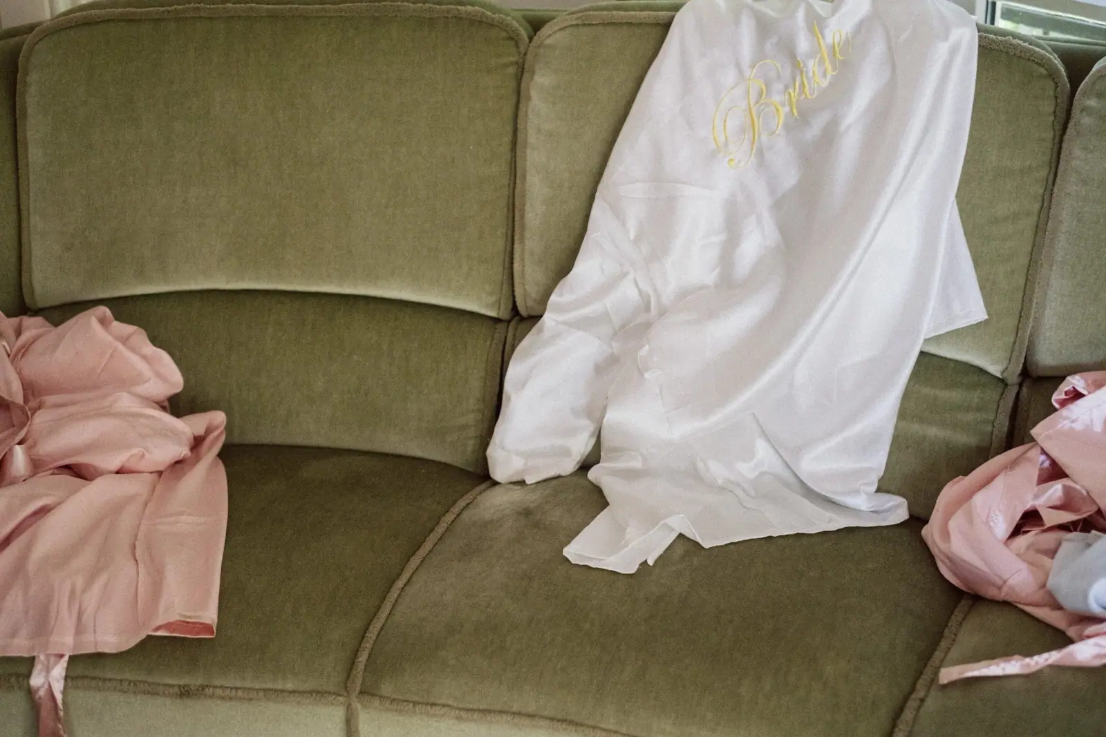 Brautkleid und Stola auf einem grünen Samtsofa