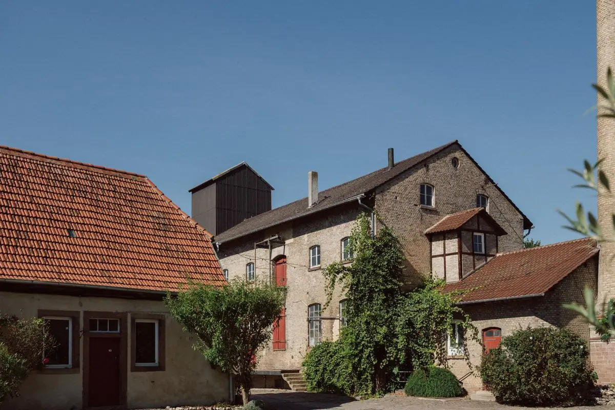Hofgut Heidesheim, Innenhof mit Fachwerk und Scheunen bei blauem Himmel