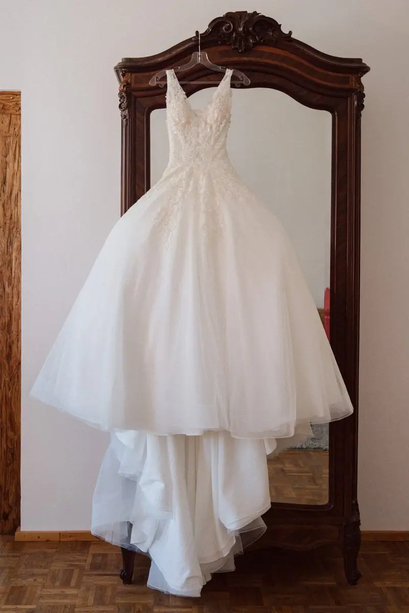 Brautkleid hängt am Holzschrank