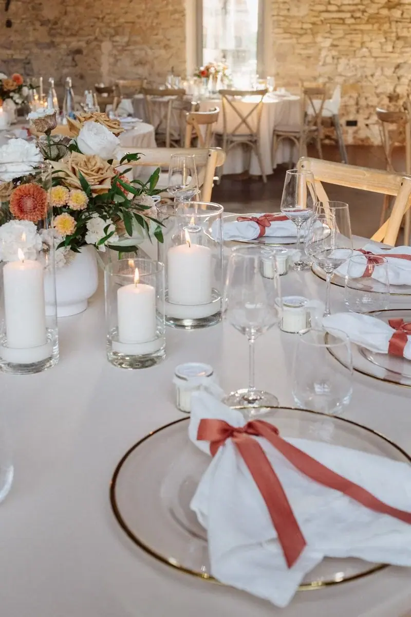 Tischdekoration mit Kerzen und Serviette mit rotem Band