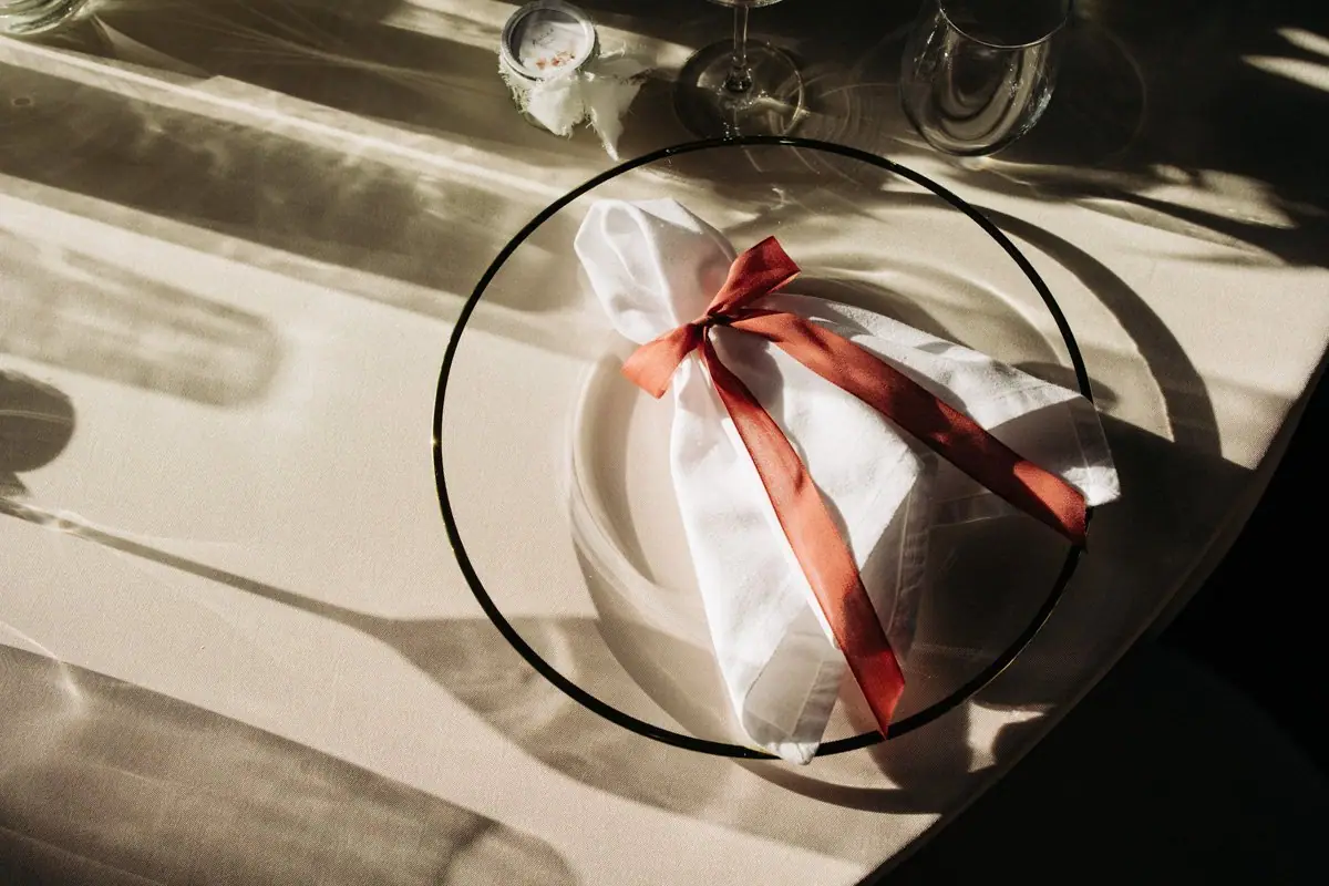 Serviette mit rotem Band, Spiegelung im Teller