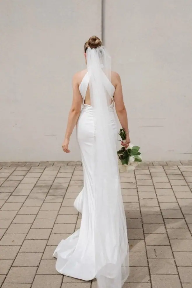 Braut von hinten im Neckholder-Kleid