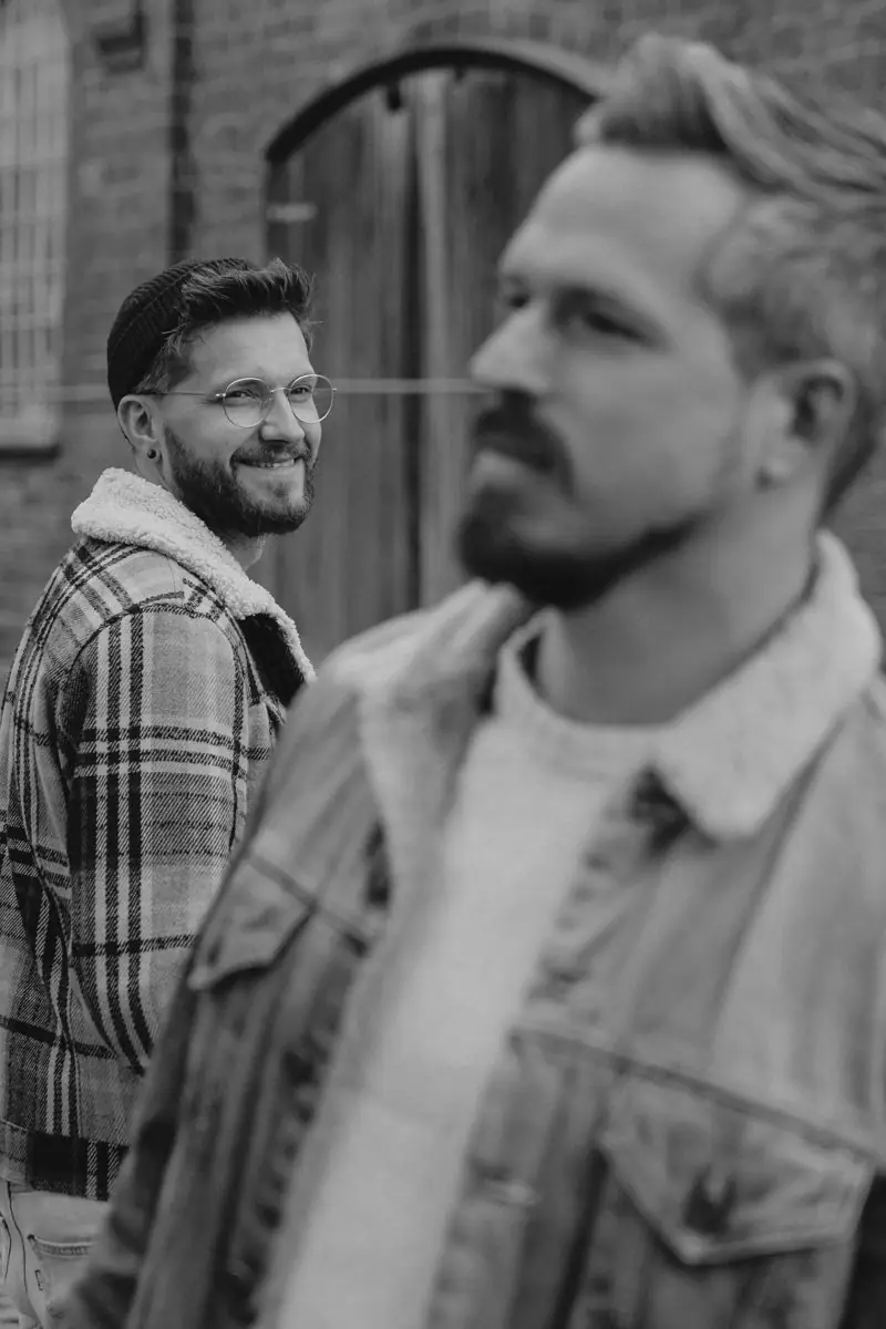 Glückliches schwules Paar bei einem Outdoor-Shooting mit professioneller Fotografin